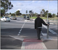 Typical 
              APS location in relation to the crosswalk and sidewalk. Australian 
              curb ramp standards allow a steeper flare than allowed by US standards. 
            